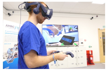 Project engineer Rob Stacey wears a virtual reality headset with his avatar in the Digital Operating Theatre shown on the screen behind him (Credit: AMRC)