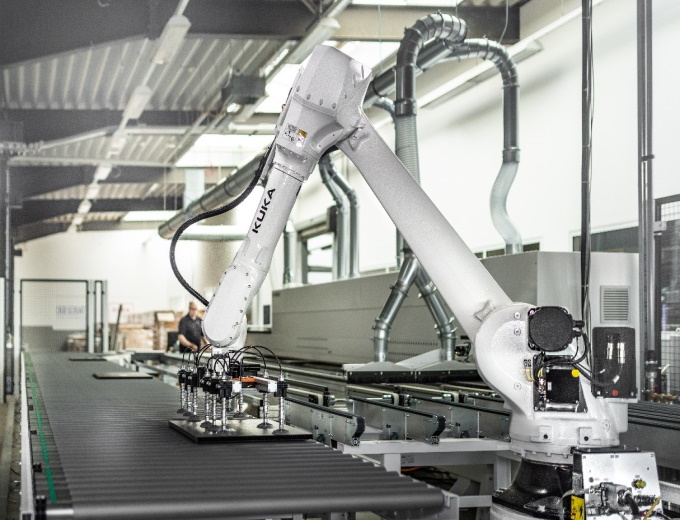 A KUKA robot from the KR IONTEC series performs handling tasks and palletizes series components